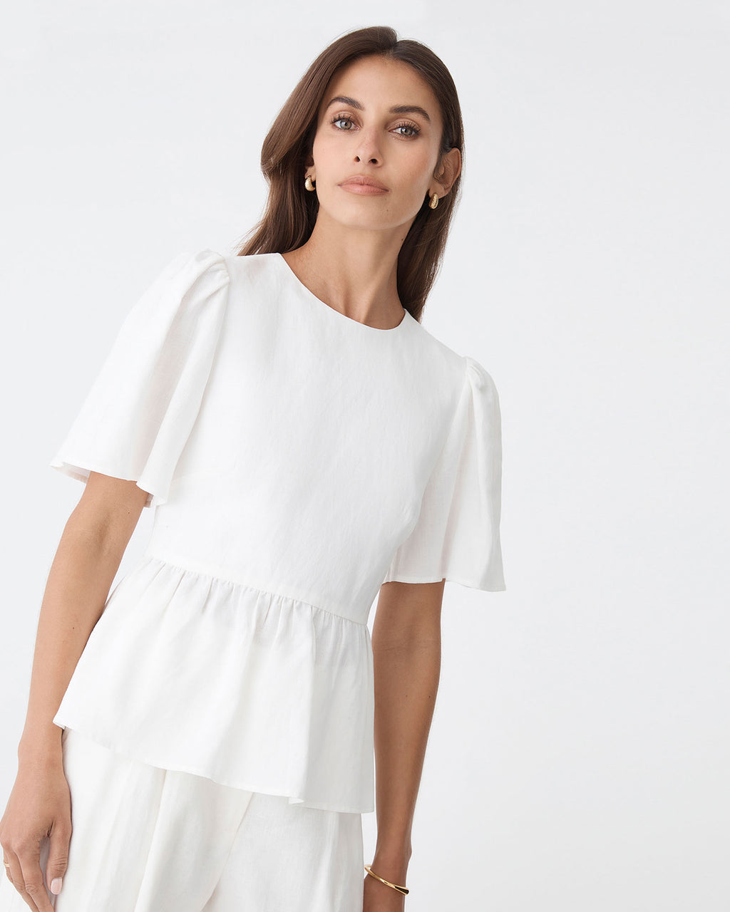 Jade Linen Peplum Top in ivory — close-up view