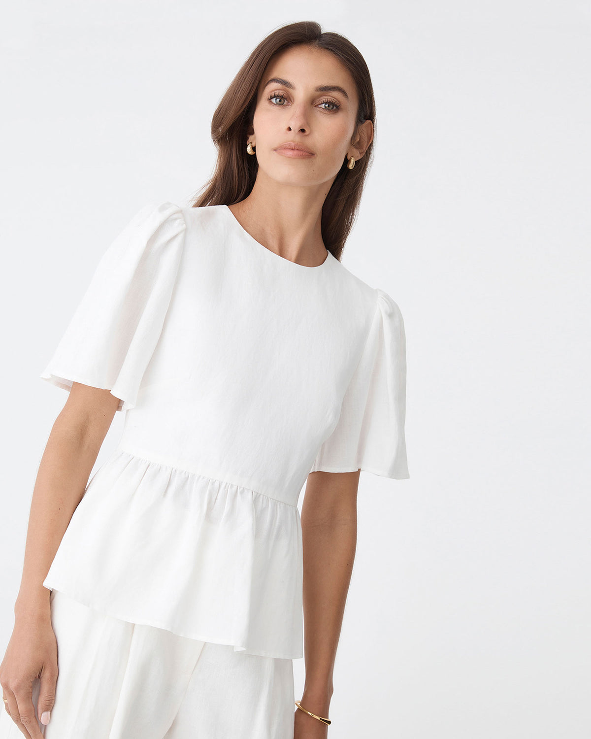 Jade Linen Peplum Top in ivory — close-up view
