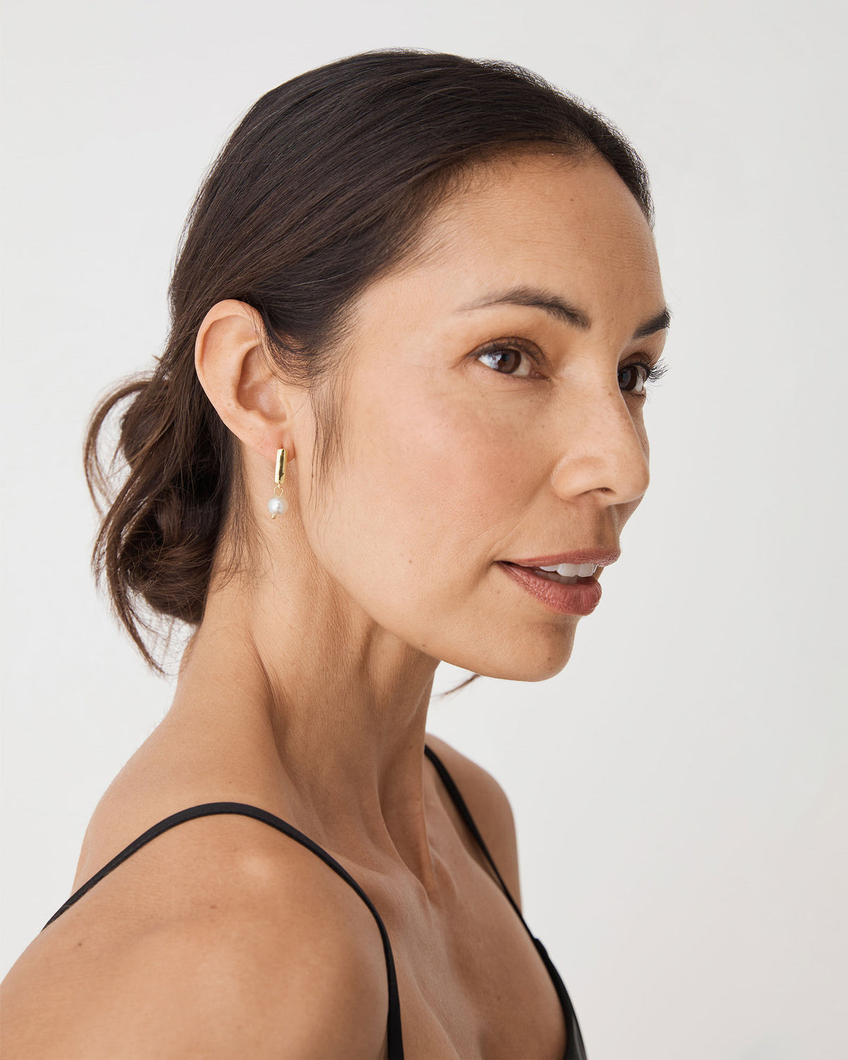 Mila Pearl Huggie Earrings in gold pearl — fabric detail